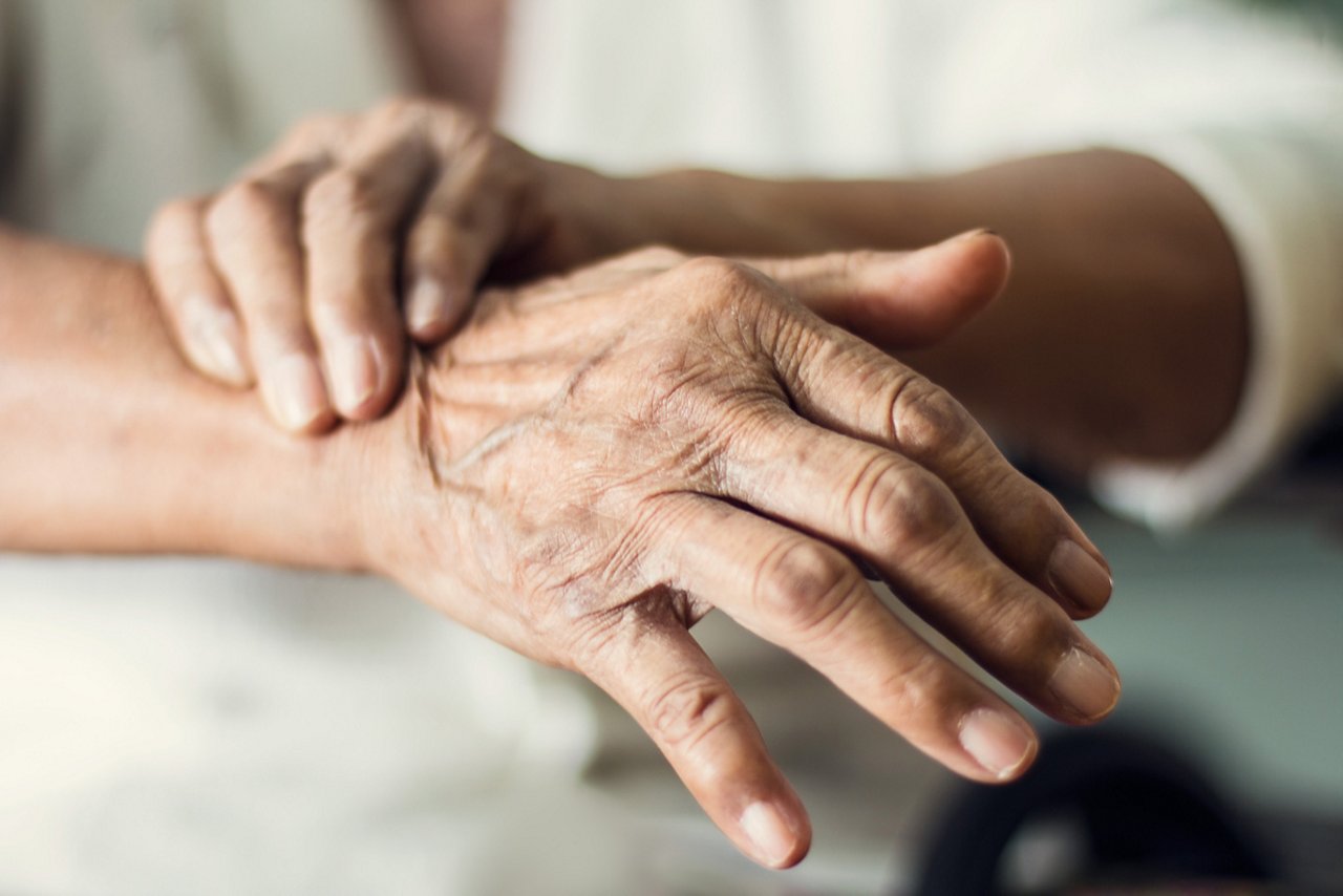 Close up hands of senior elderly woman patient suffering from pakinson's desease symptom. Mental health and elderly care concept
