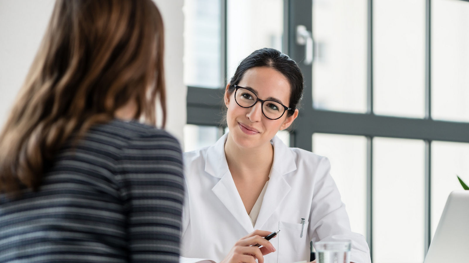 Female physician listening to her patient during consultation