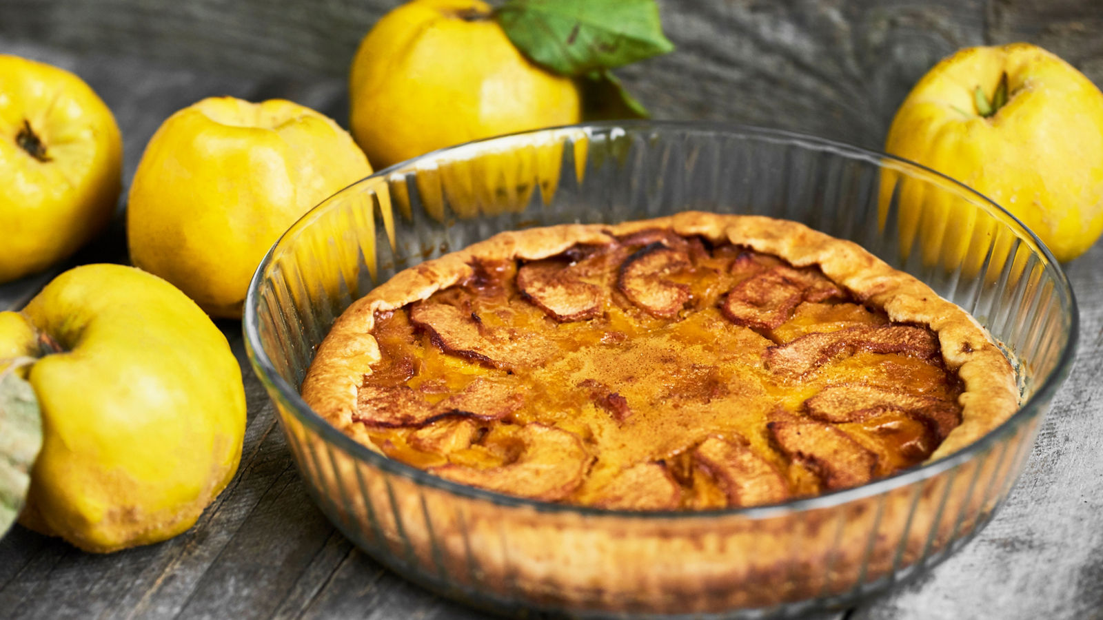 Homemade apple quince pie with fresh fruits on rustic wooden background. Top view