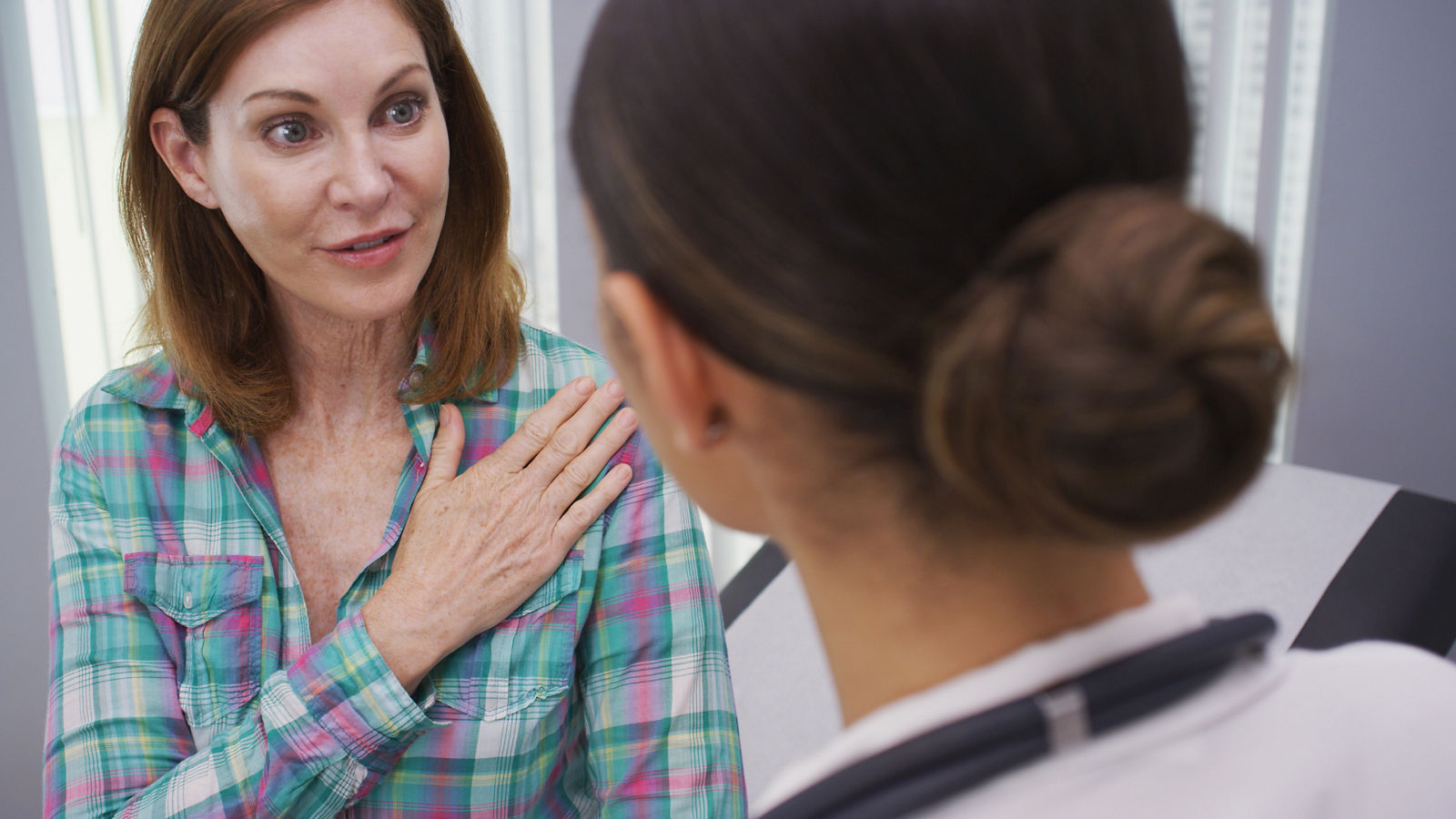 Patienten Beratungsgespräch,Close up of charming mid aged patient explaining to doctor her shoulder pain