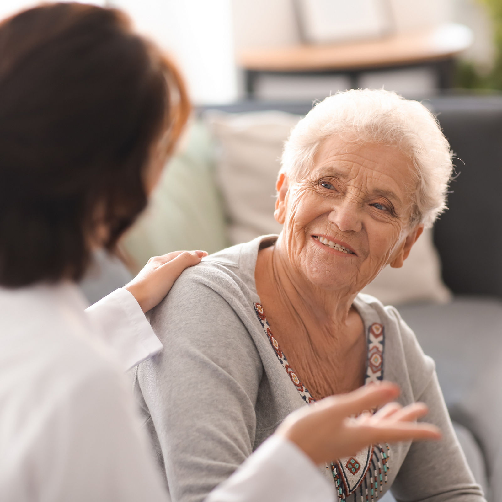 Young doctor visiting elderly woman at home