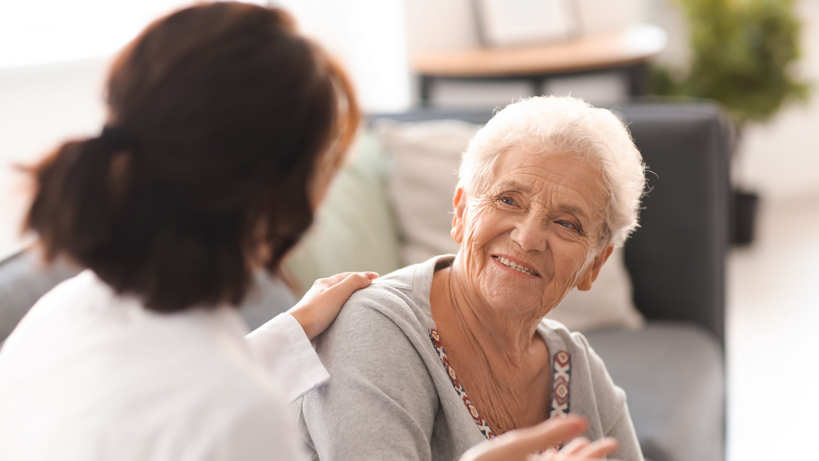 Young doctor visiting elderly woman at home