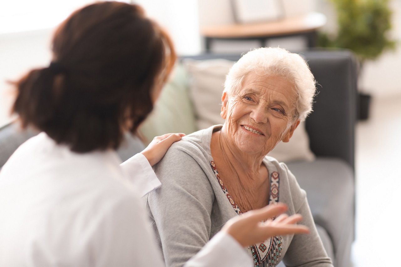 Young doctor visiting elderly woman at home