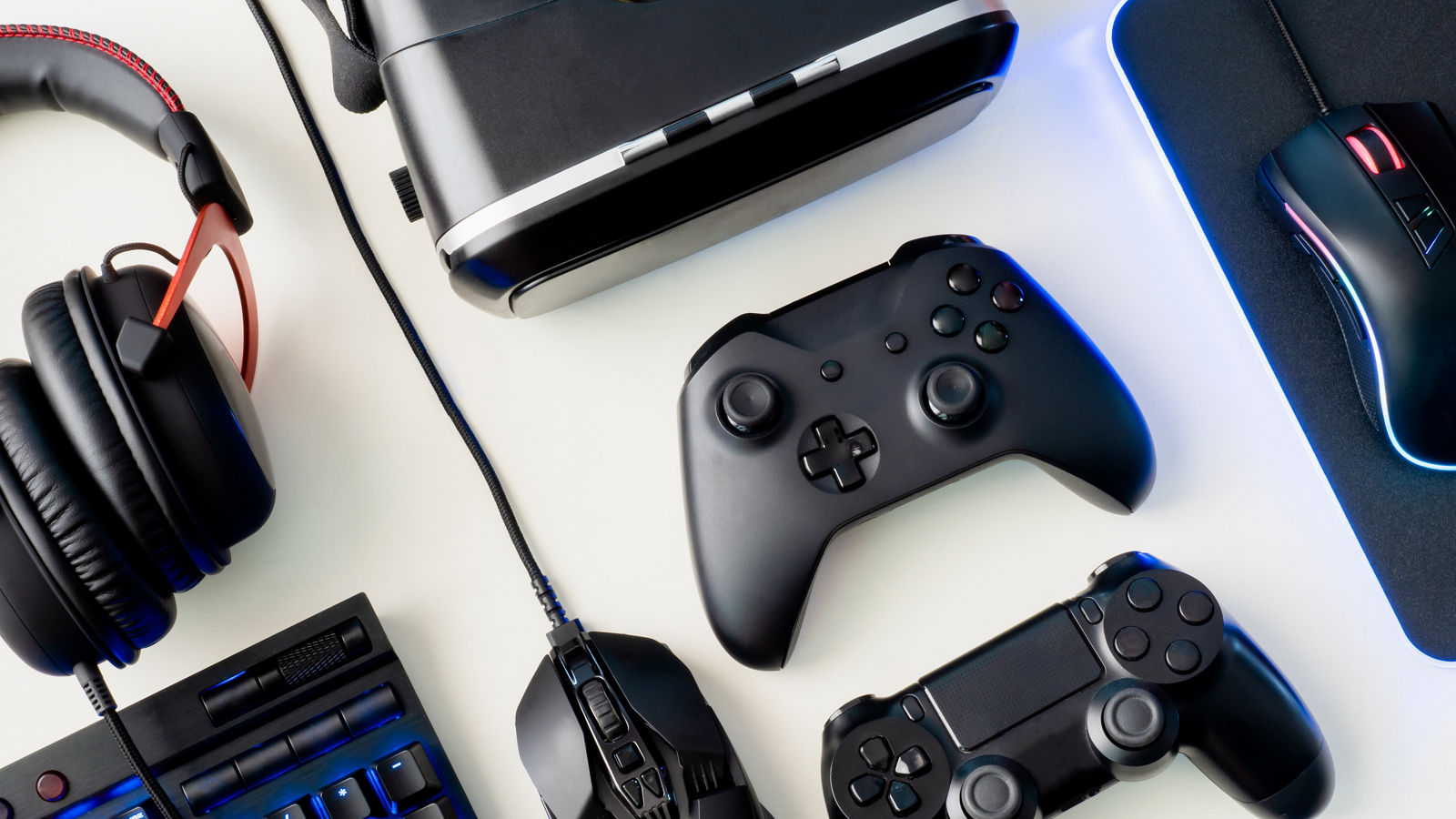 gamer workspace concept, top view a gaming gear, mouse, keyboard, joystick, headset and mouse pad on white table background
