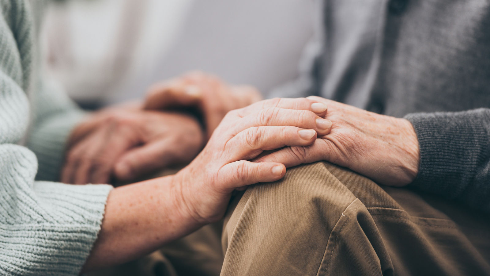 cropped view of retired couple holding hands 