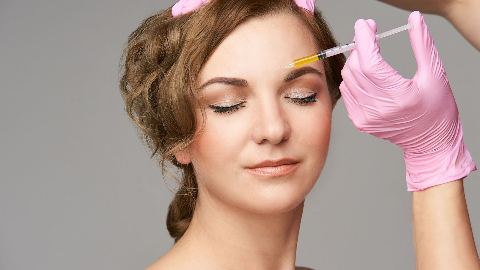Face needle injection. Young woman cosmetology procedure. Doctor gloves. Brow
