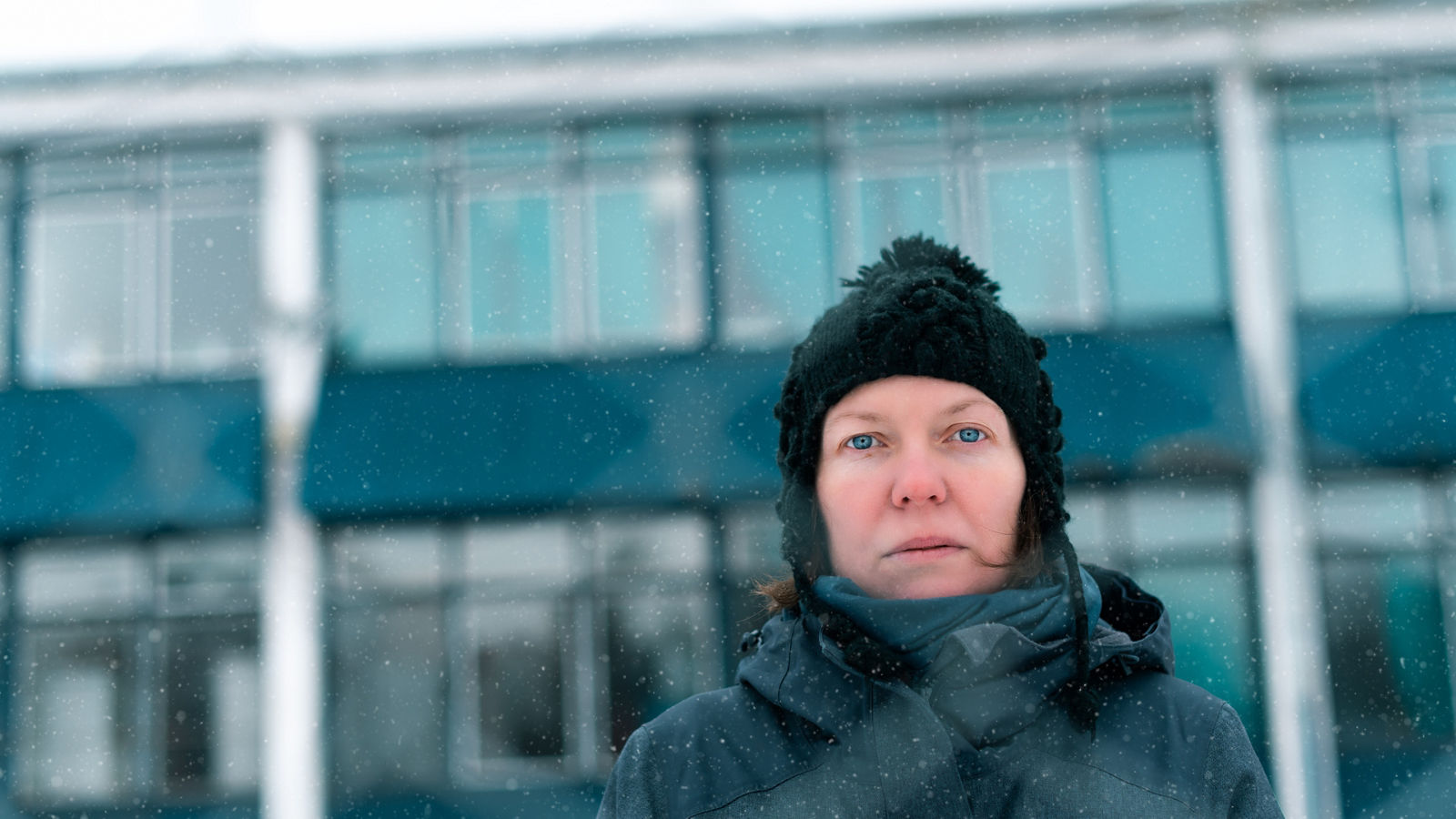 Worried concerned serious woman behind chain-link fence