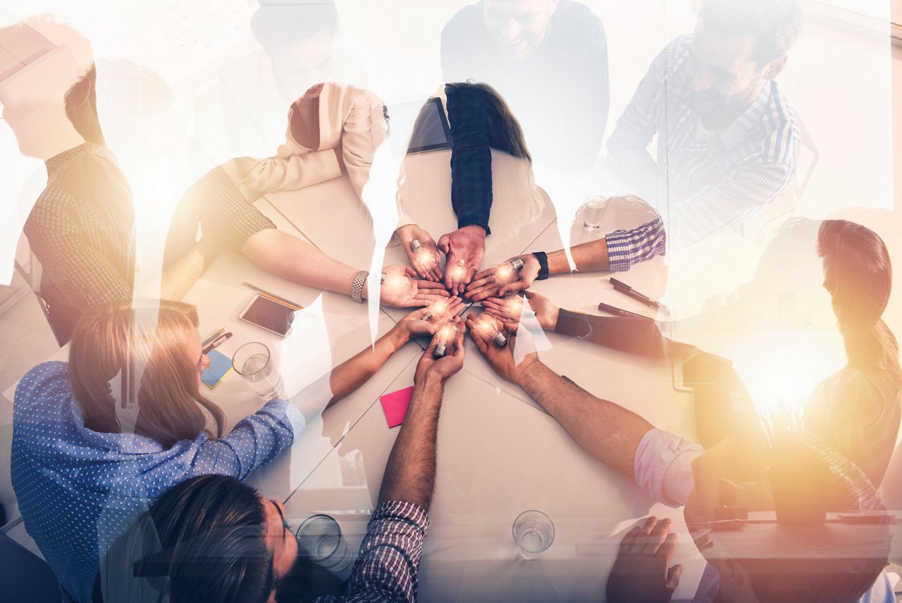 Teamwork and brainstorming concept with businessmen that share an idea with a lamp. Concept company startup. Double exposure