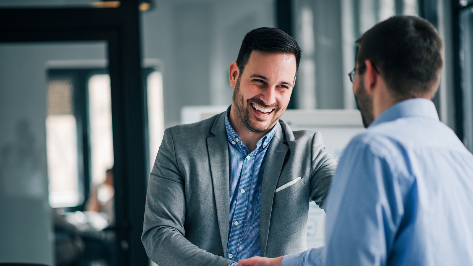 Portrait of cheerful young manager handshake with new employee. 