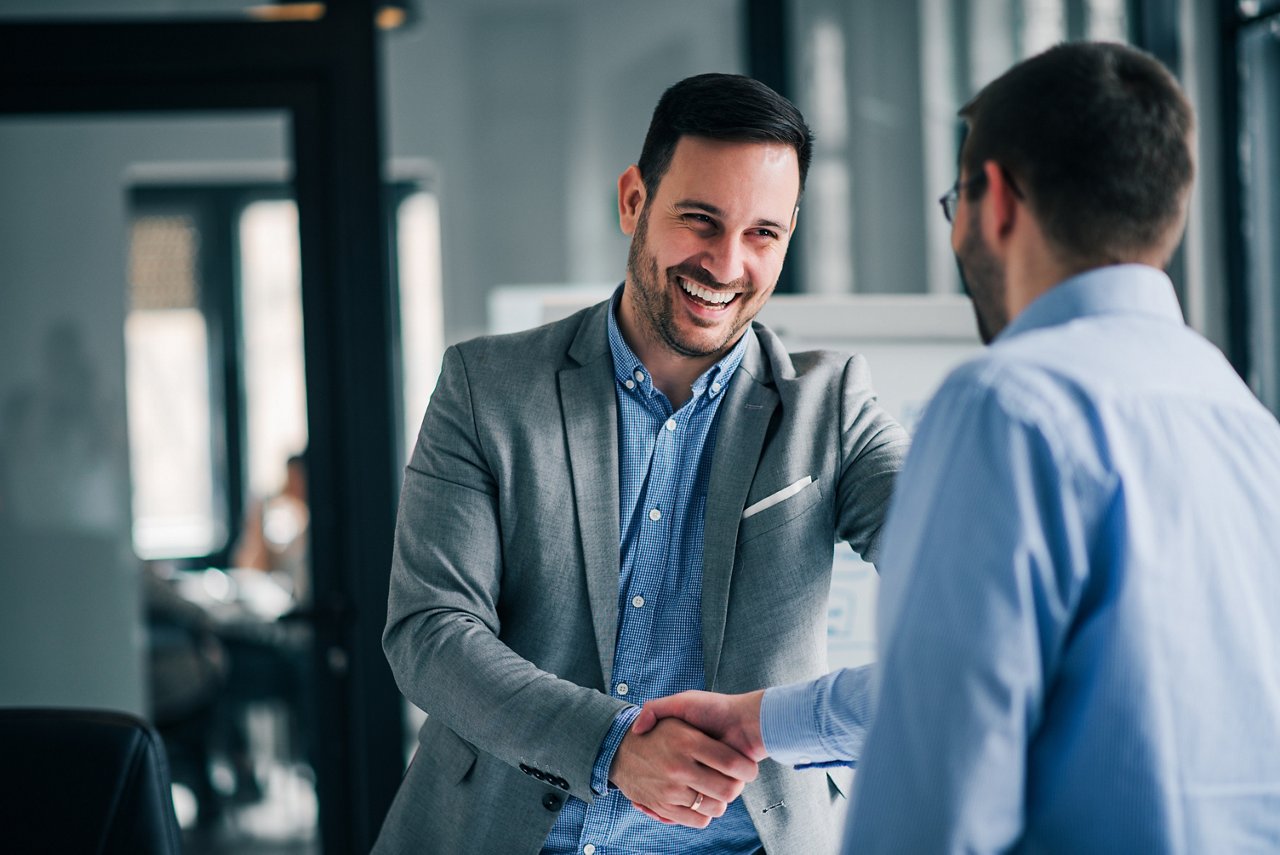 Portrait of cheerful young manager handshake with new employee. 