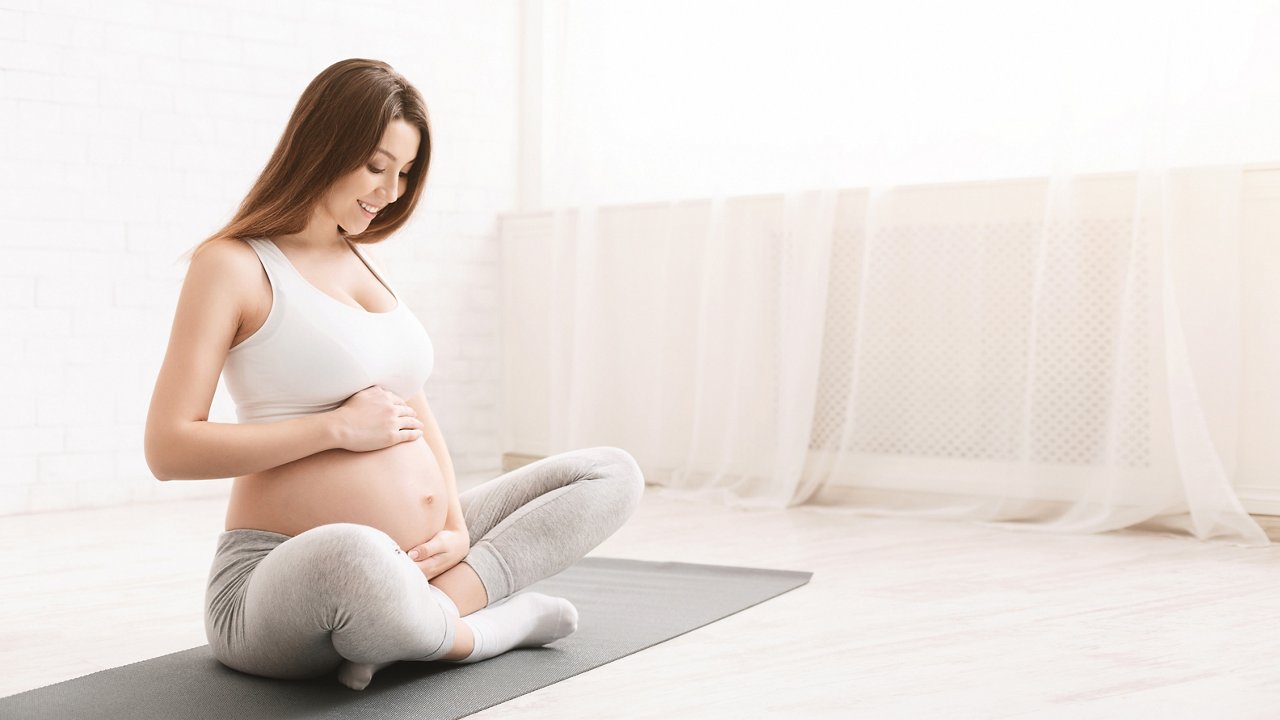 Active millennial pregnant woman practicing fitness exercises, baby like it, empty space