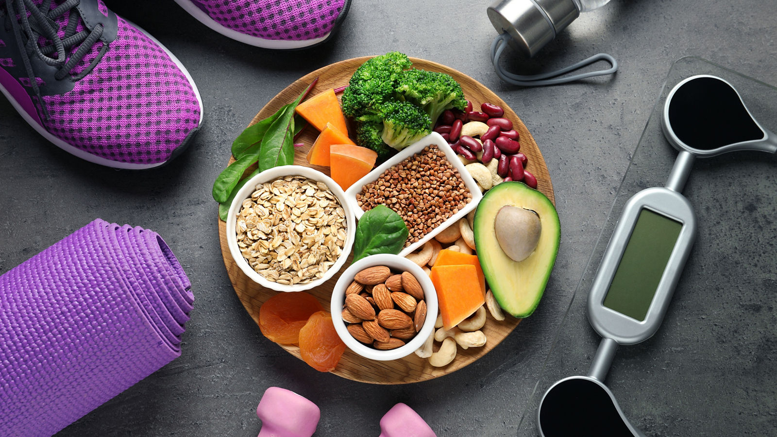 Plate with heart-healthy products and sports equipment on grey background, flat lay
