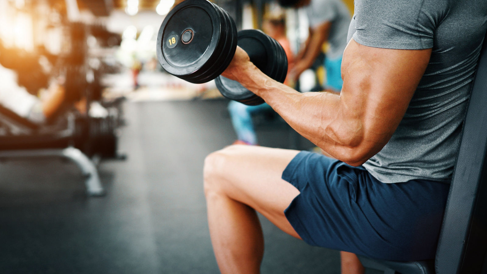 Determined handsome and young male working out in gym