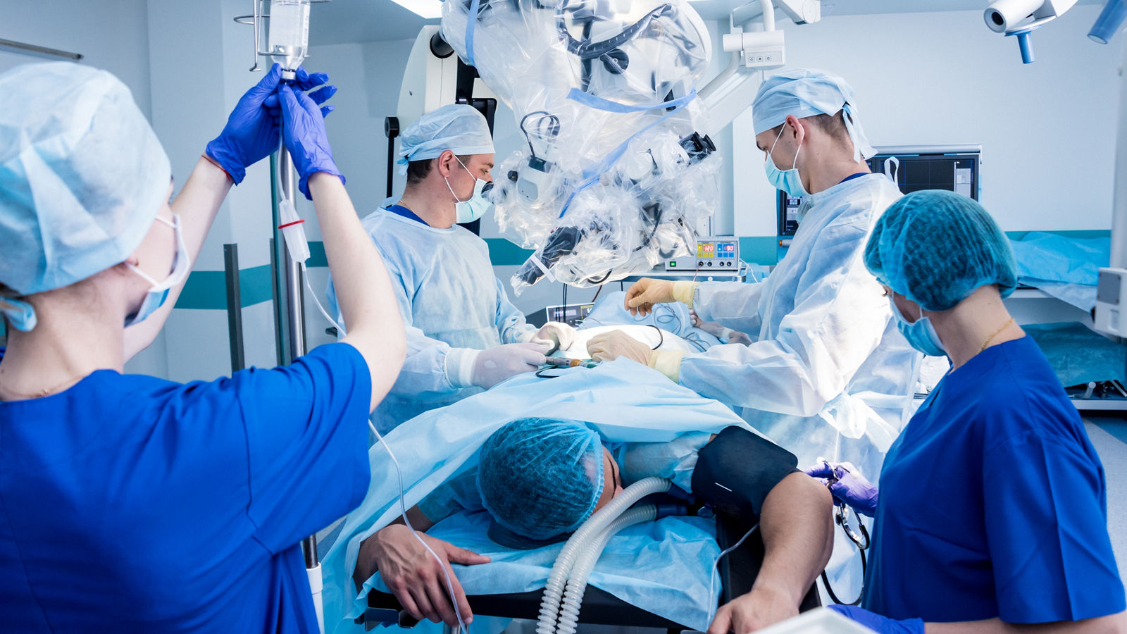 Spinal surgery. Group of surgeons in operating room with surgery equipment. Laminectomy