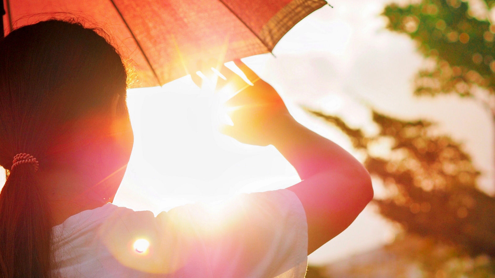 Hot weather can cause dehydration and sunstroke The girl is holding an umbrella and raising her hand. To block the hot sunlight.. (Devices that are not specific to a particular brand),Hot weather can cause dehydration and sunstroke The girl is hold