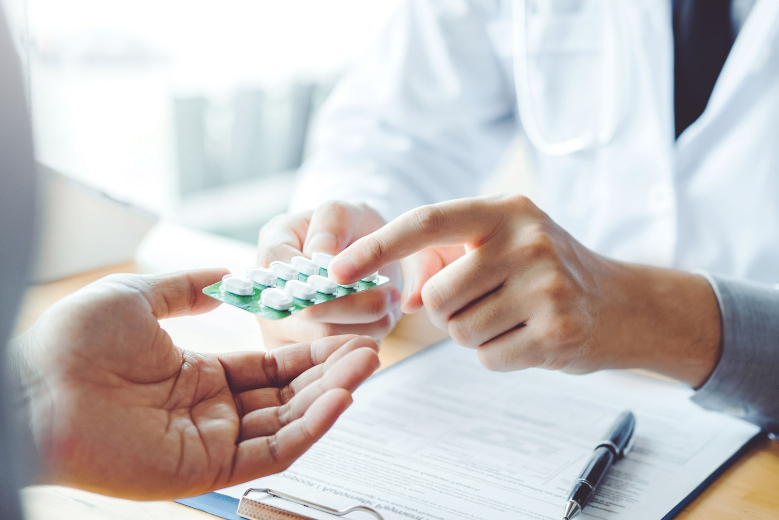 Doctor or physician recommend pills medical prescription to male Patient  hospital and medicine concept