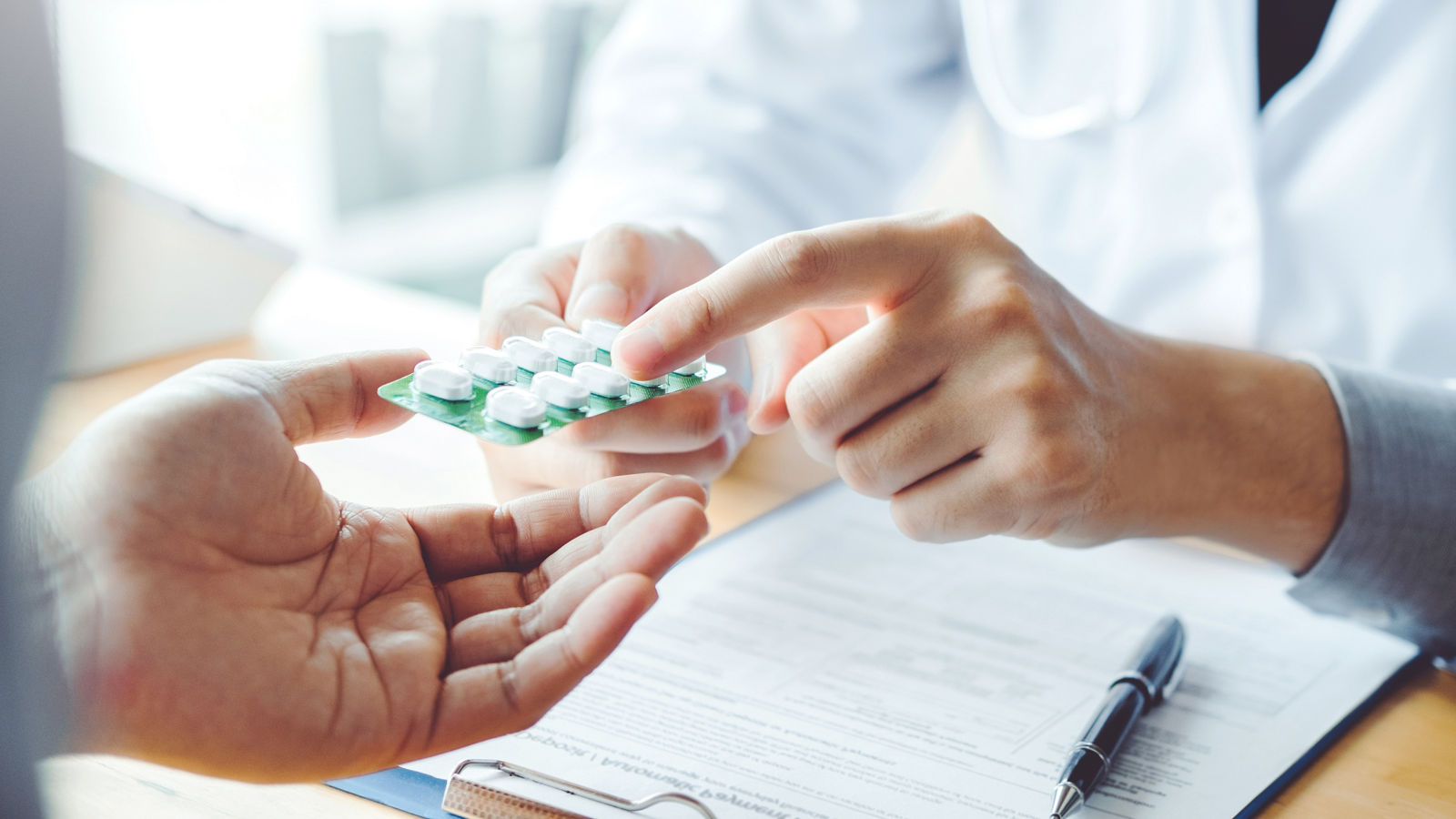 Doctor or physician recommend pills medical prescription to male Patient  hospital and medicine concept