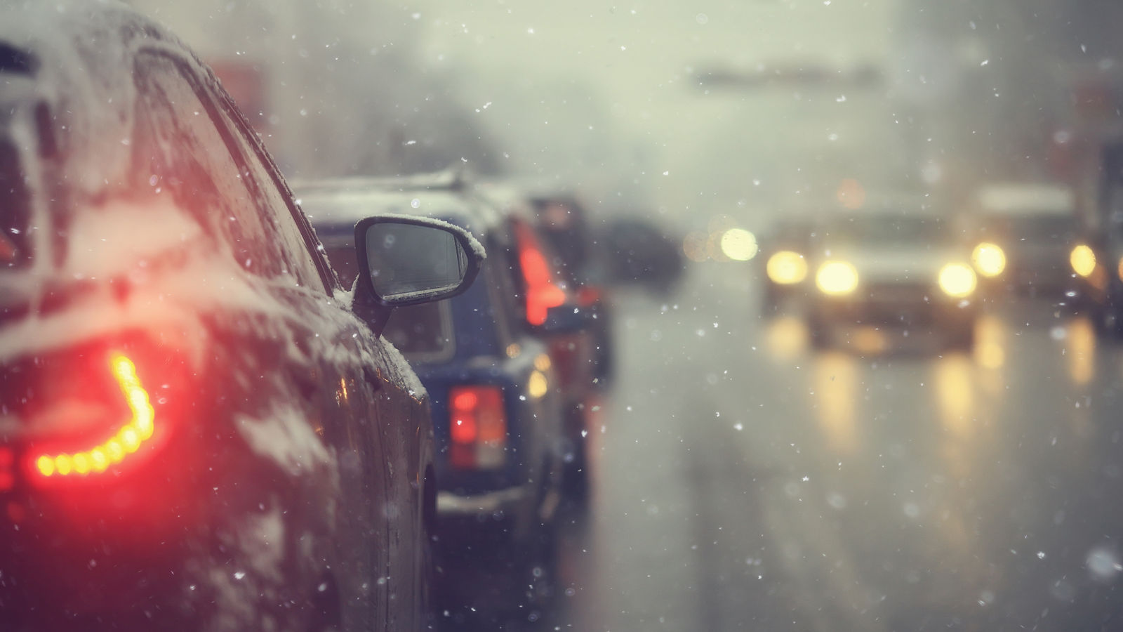 cars on winter road traffic jam city / winter weather on the city highway, the view from car in the fog and snow road