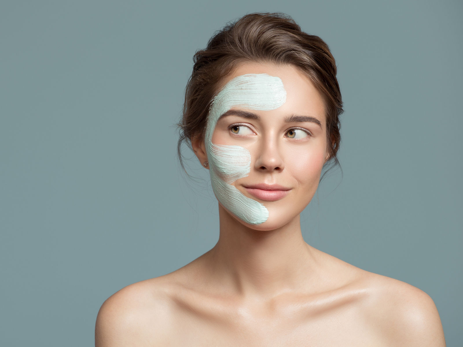 Portrait of beautiful woman with bluel cream mask on her face.