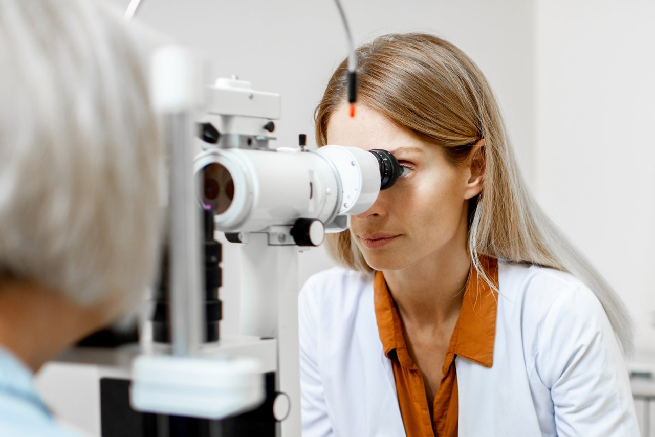 Ophthalmologist examining eyes of a senior patient using microscope during a medical examination in the ophthalmologic office