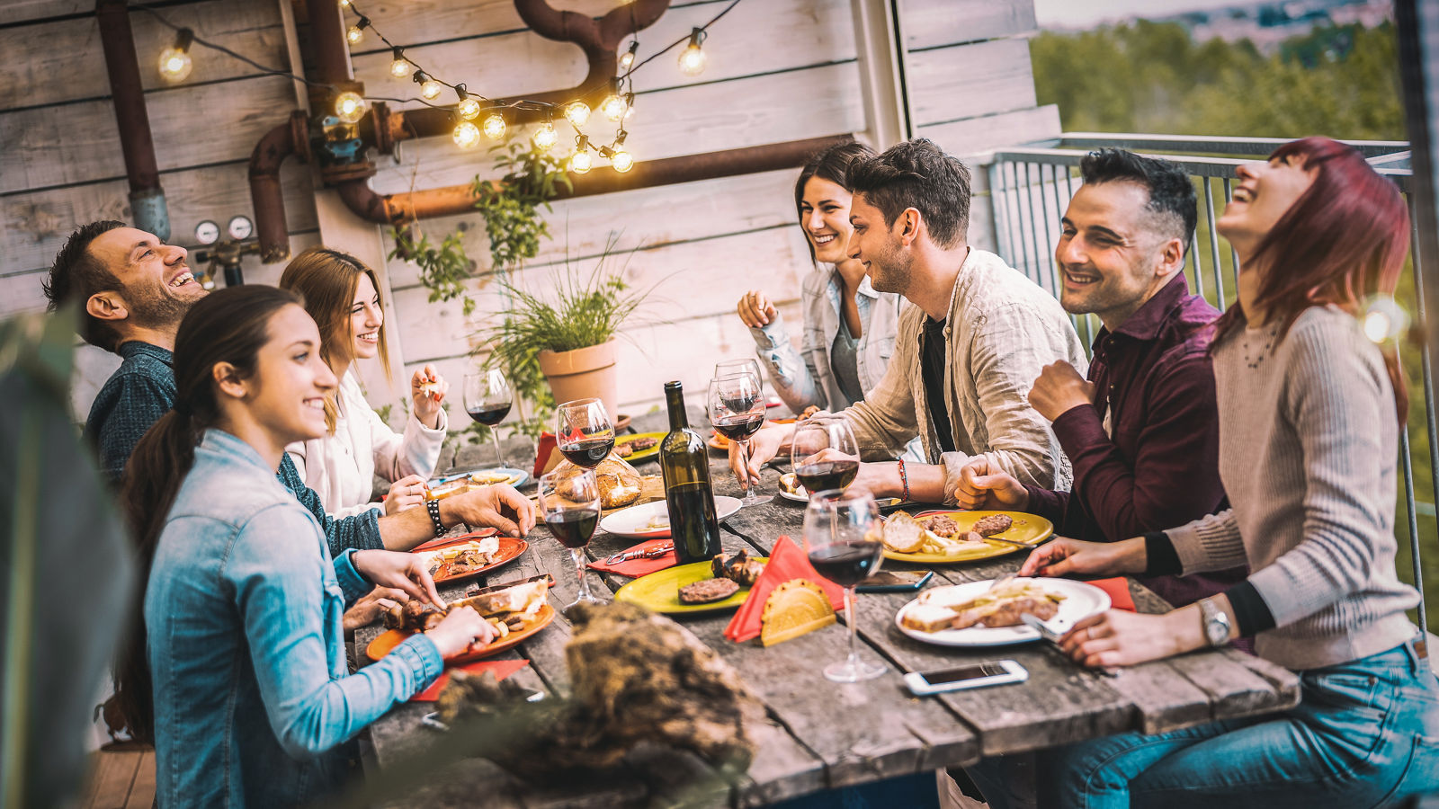 Young people dining and having fun drinking red wine together on balcony rooftop dinner party - Happy friends eating bbq food at restaurant patio - Millannial life style concept on warm evening filter,Young people dining and having fun drinking red wine together on