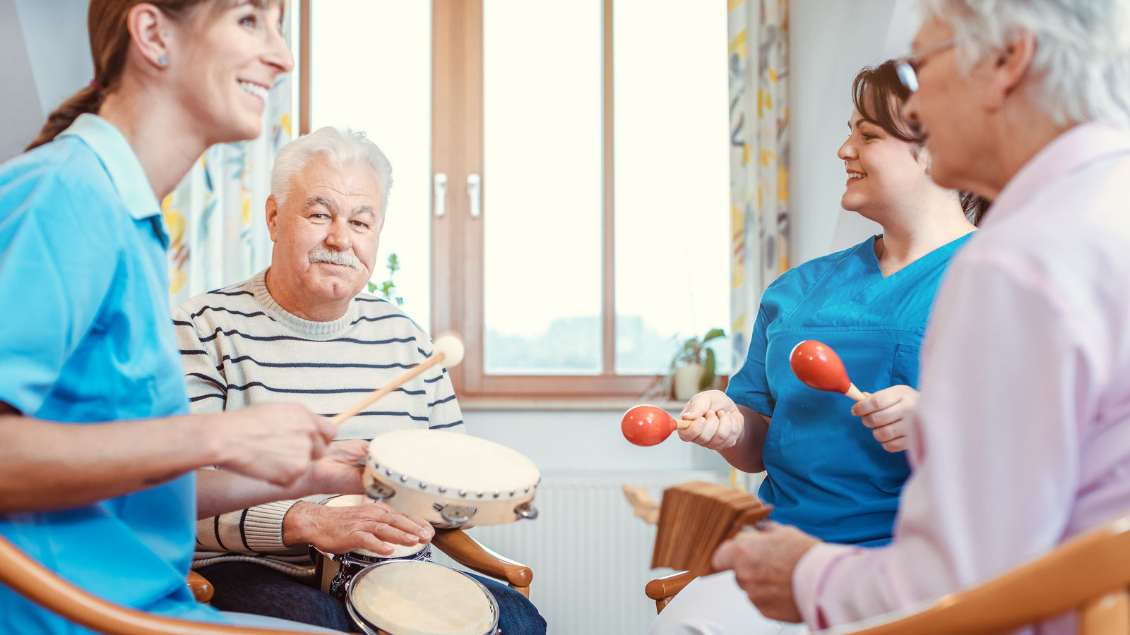 Seniors in nursing home making music with rhythm instruments