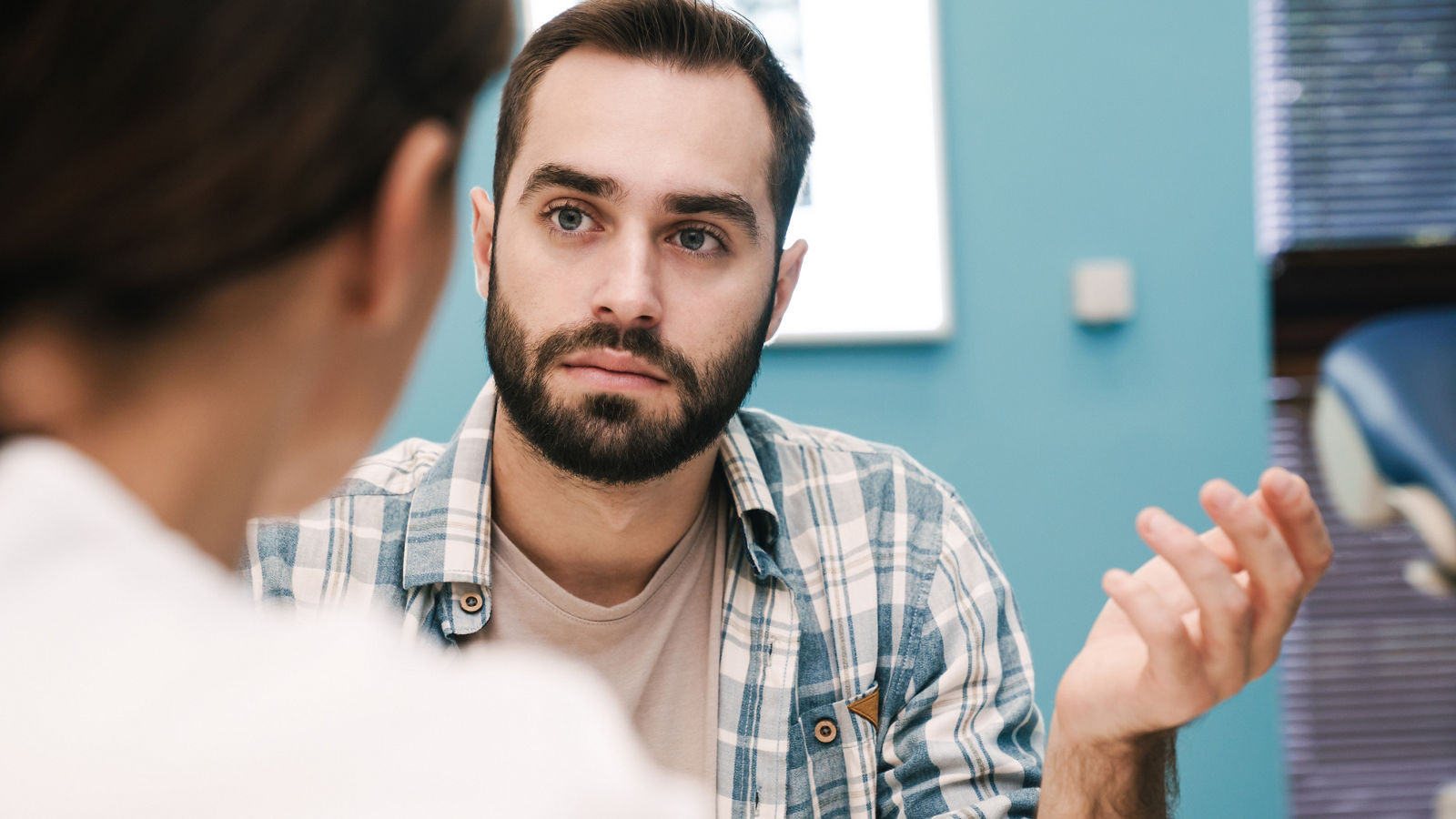 Image of female doctor and young patient man talking in hospital room