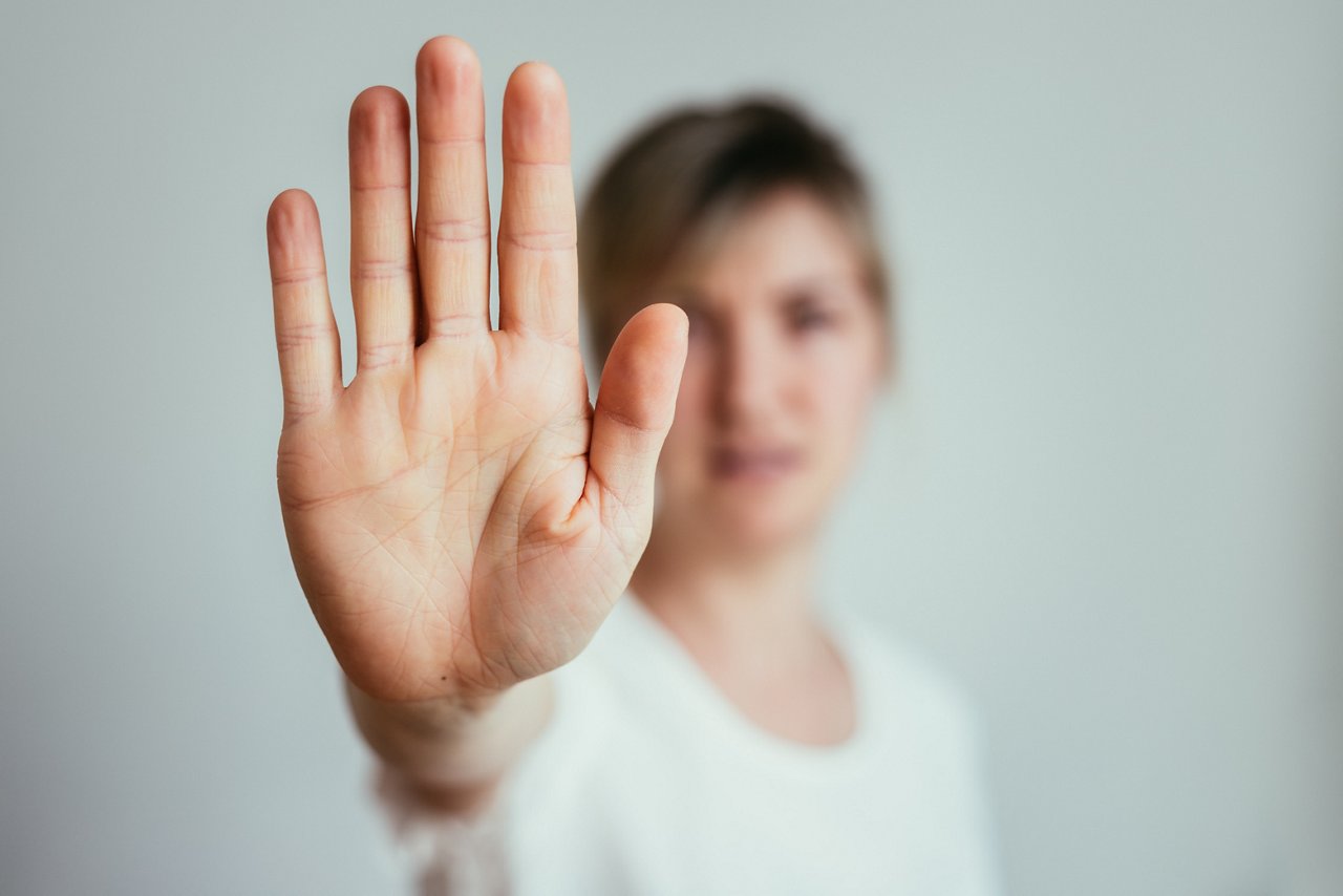  Frau streckzt der Kamera die Flache hand entgegen