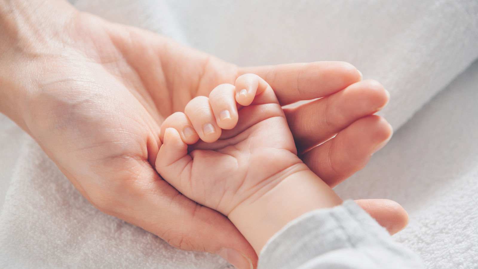 lose-up baby hand on mother's hands