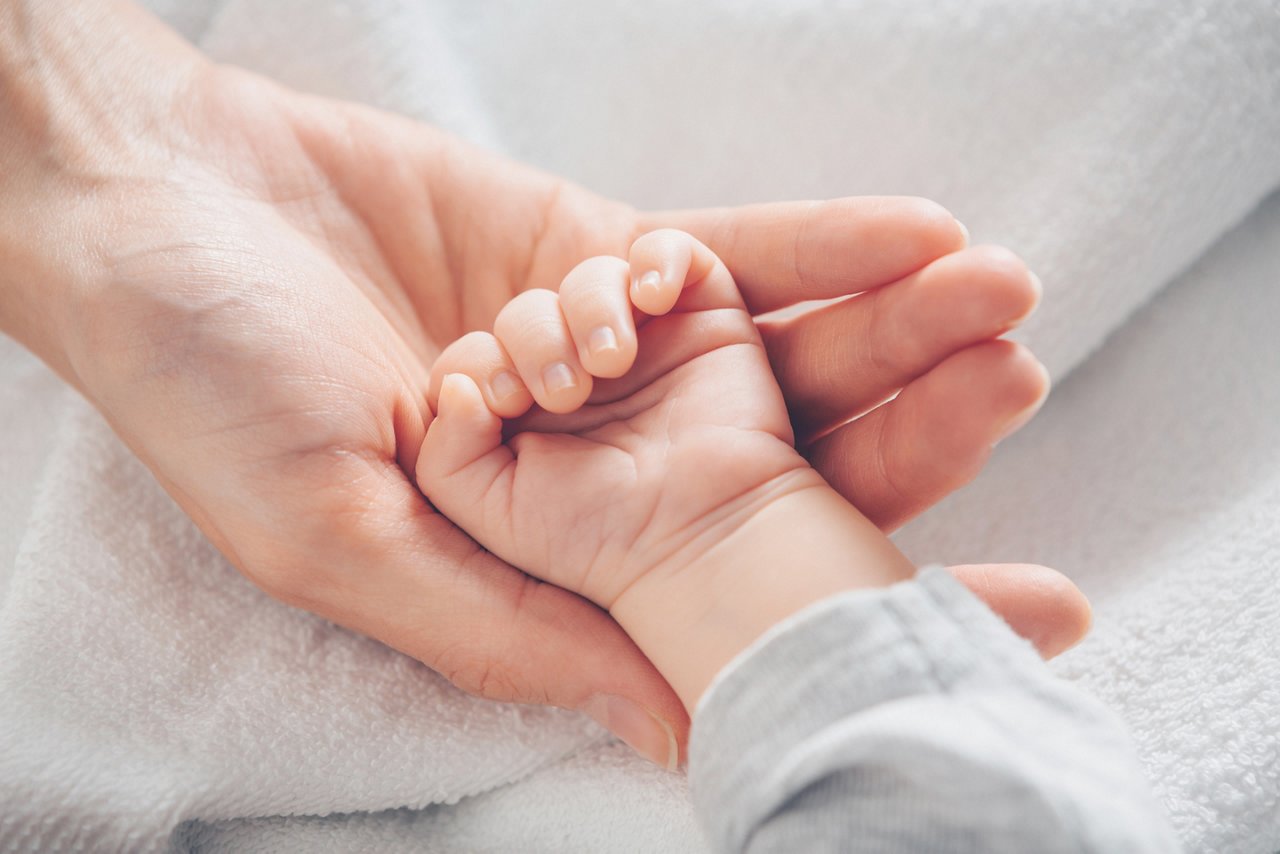 Close-up baby hand on mother's hands. Love and family concept. Motherhood. Love and family concept