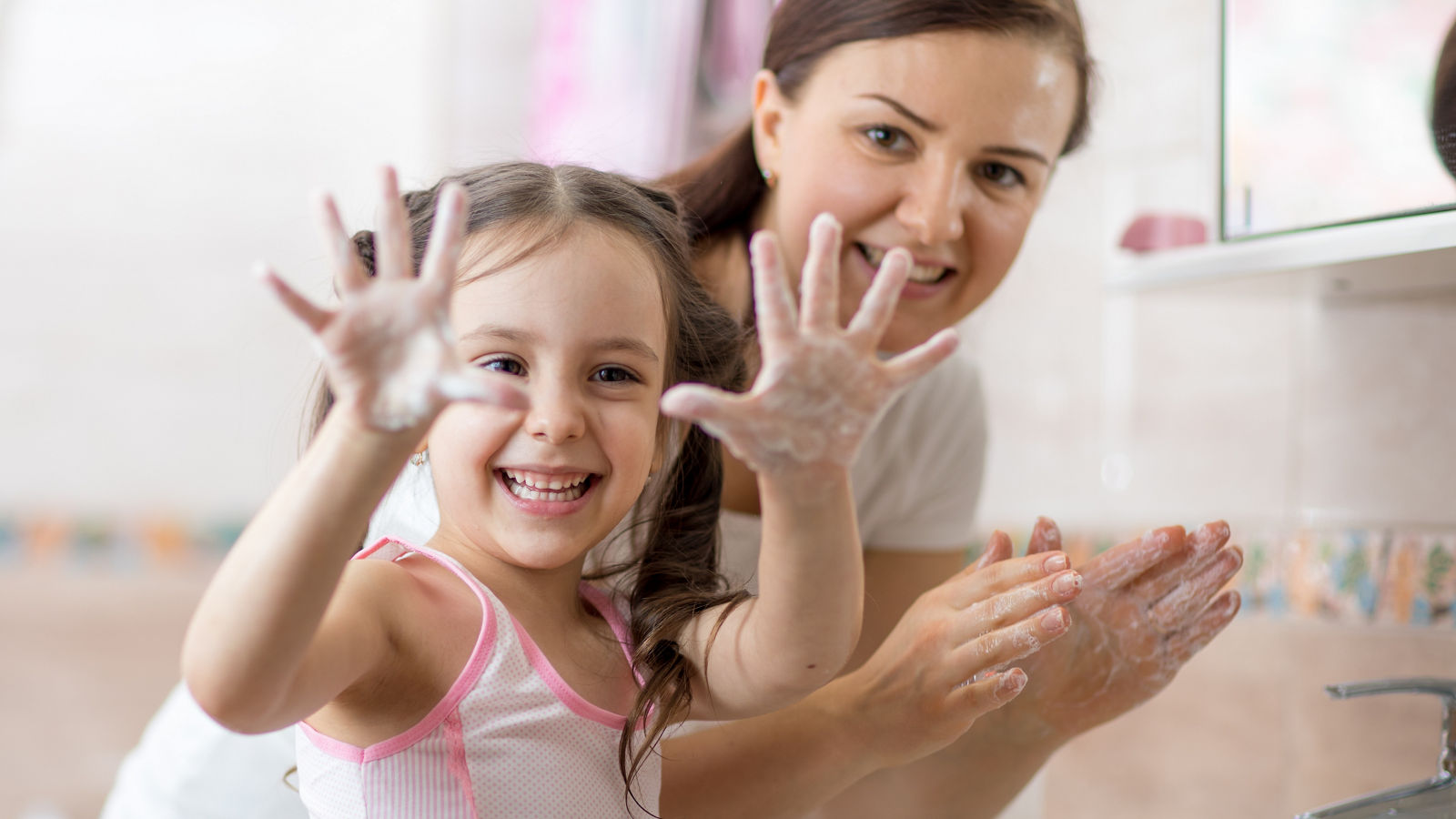 Kid washing hands and showing soapy palms