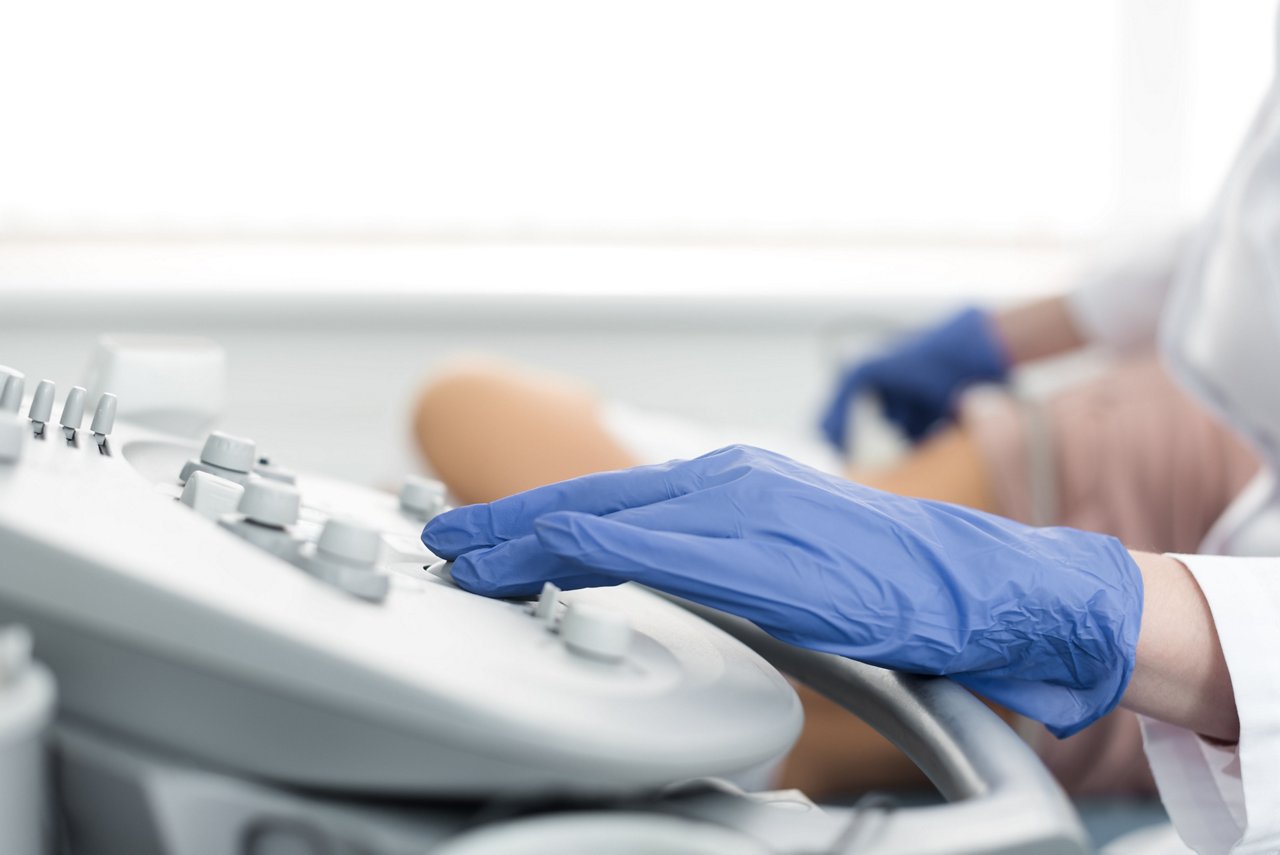 cropped view of doctor examining kidney of patient with ultrasound scan in clinic