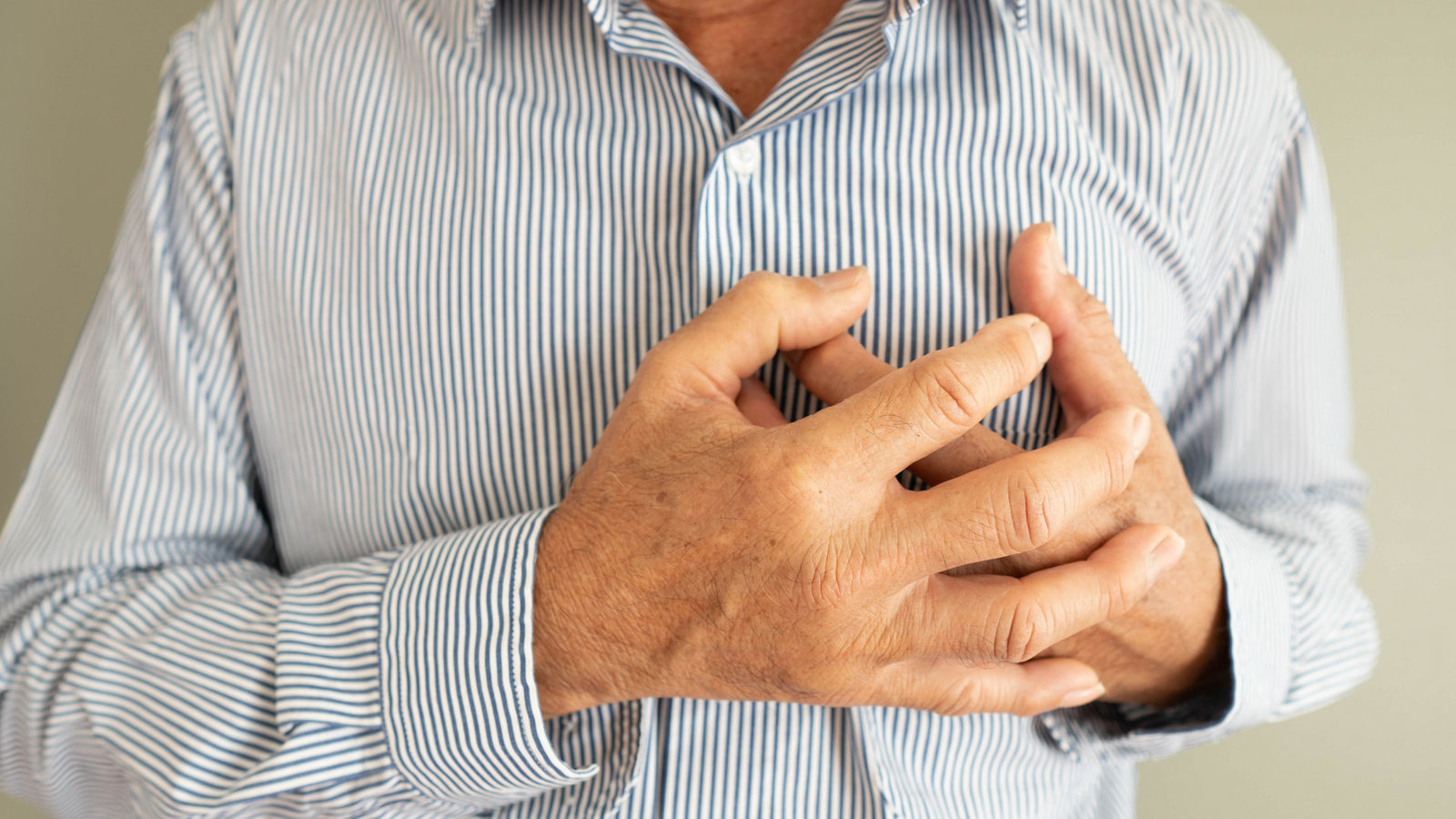 Heart attack problems. Elderly man suffering from severe chest pain. Warning signs of unstable angina or myocardrial infarction disease. Health care and cardiological concept. Close up.