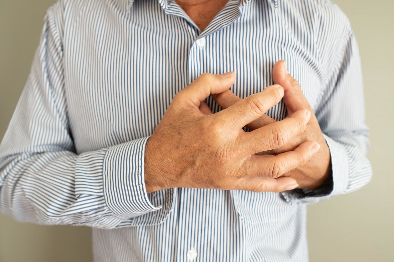Heart attack problems. Elderly man suffering from severe chest pain. Warning signs of unstable angina or myocardrial infarction disease. Health care and cardiological concept. Close up.