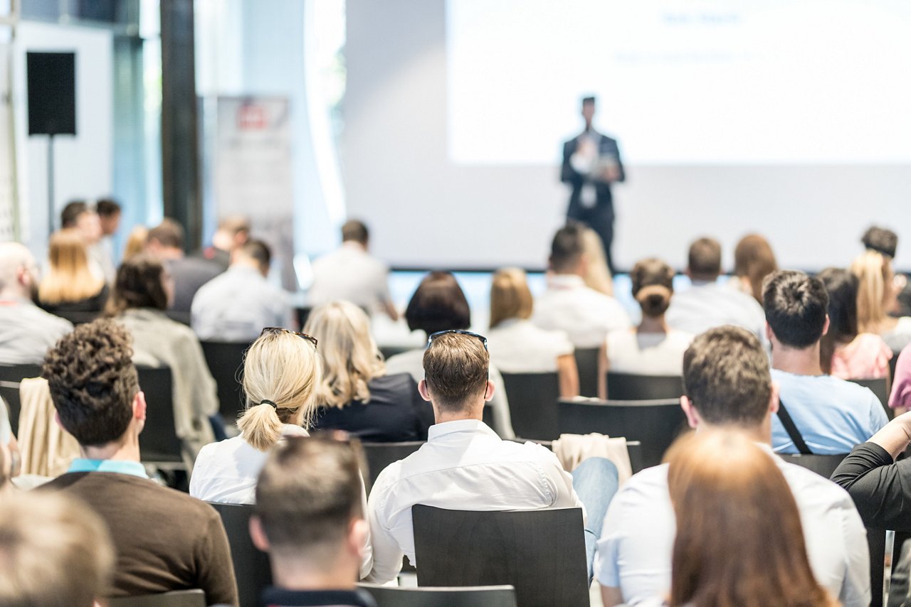 Male business speaker giving a talk at business conference event.