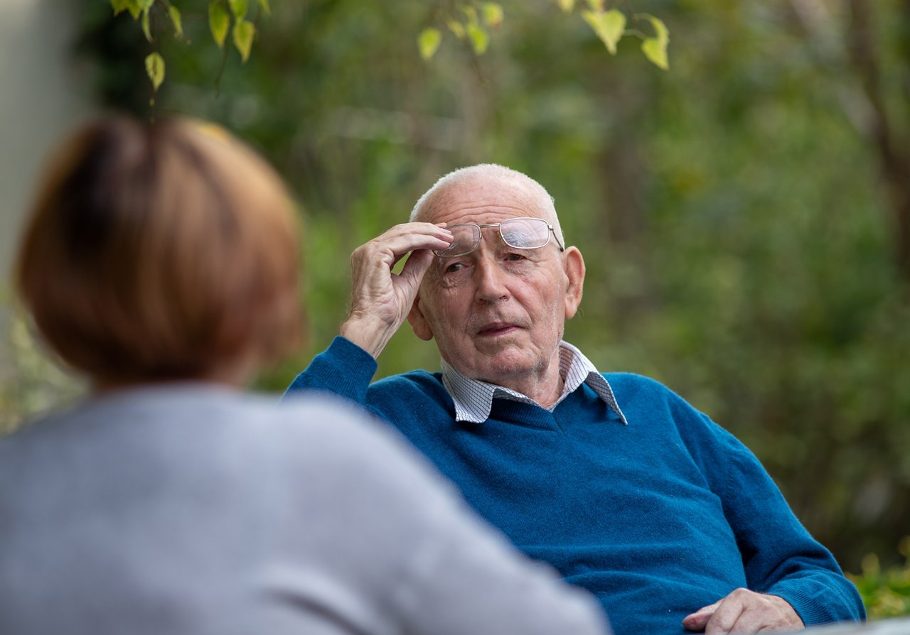 Portrait of senior man talking to his wife in park