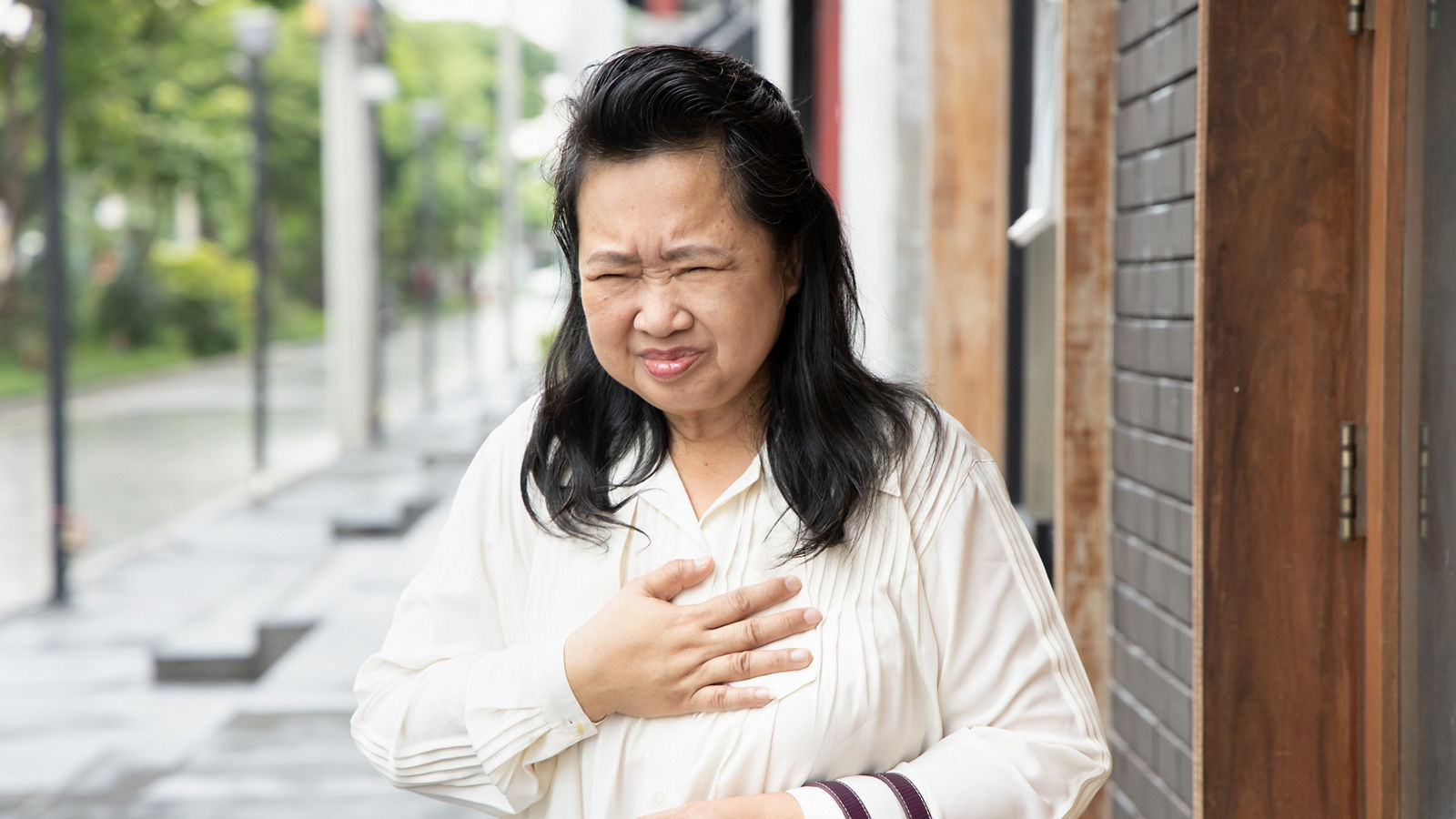 sick old senior woman suffering from GERD or acid reflux