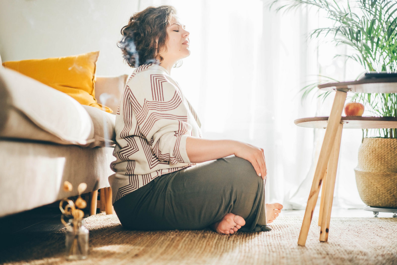  Plus size woman doing yoga and meditation at home.