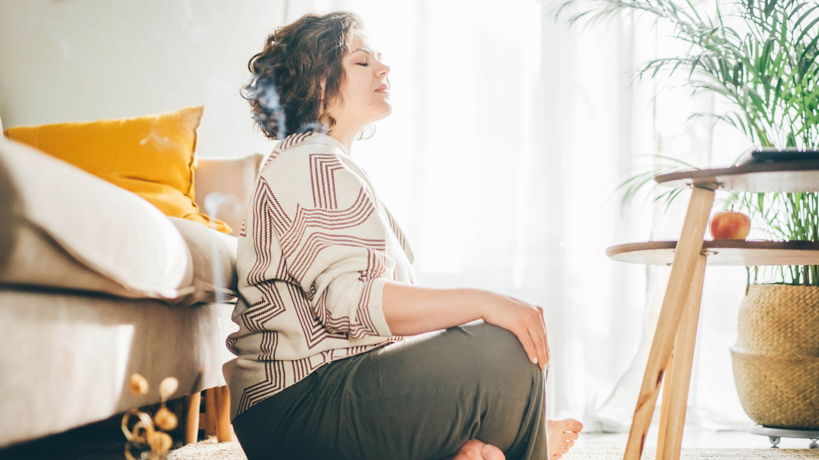  Plus size woman doing yoga and meditation at home.