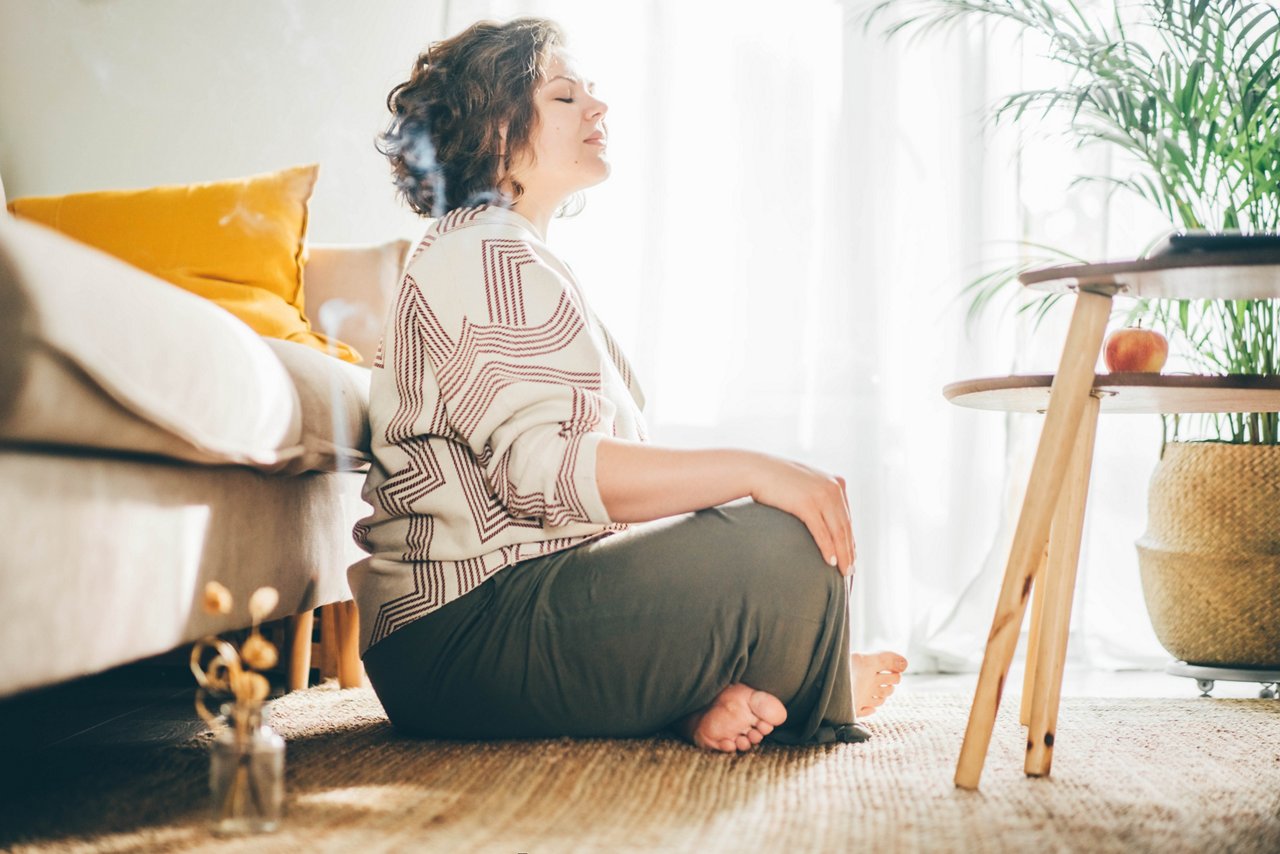  Plus size woman doing yoga and meditation at home.