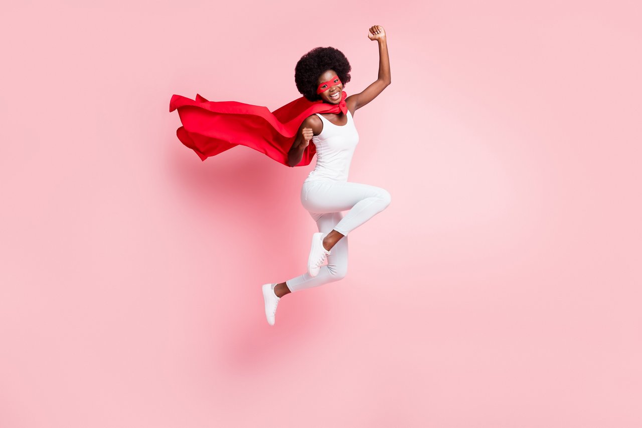 Full length body size view of active cheery girl jumping rejoicing wearing hero costume isolated on pink pastel color background.