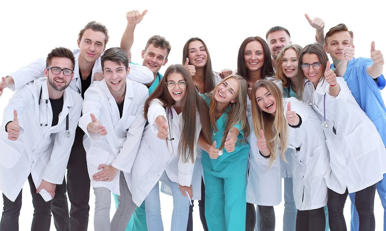 in full growth. group of hilarious doctor interns showing thumbs up