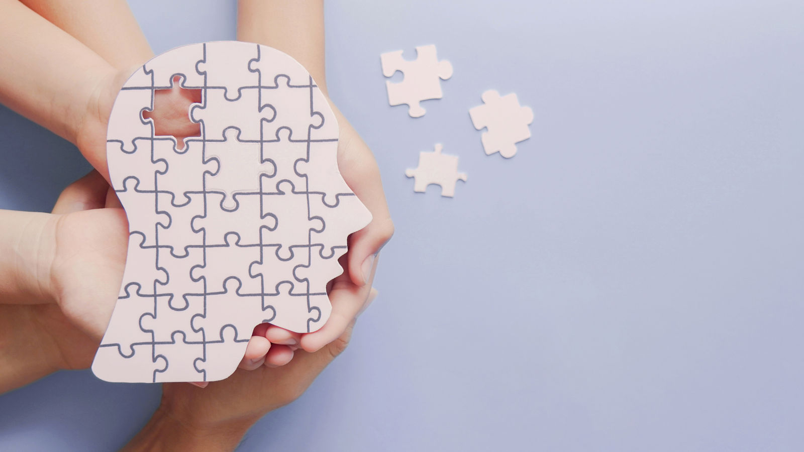 Adult and children hands holding brain with puzzle paper cutout, autism, memory loss, dementia, epilepsy and alzheimer awareness, world mental health day concept,Adult and children hands holding brain with puzzle paper cutout,