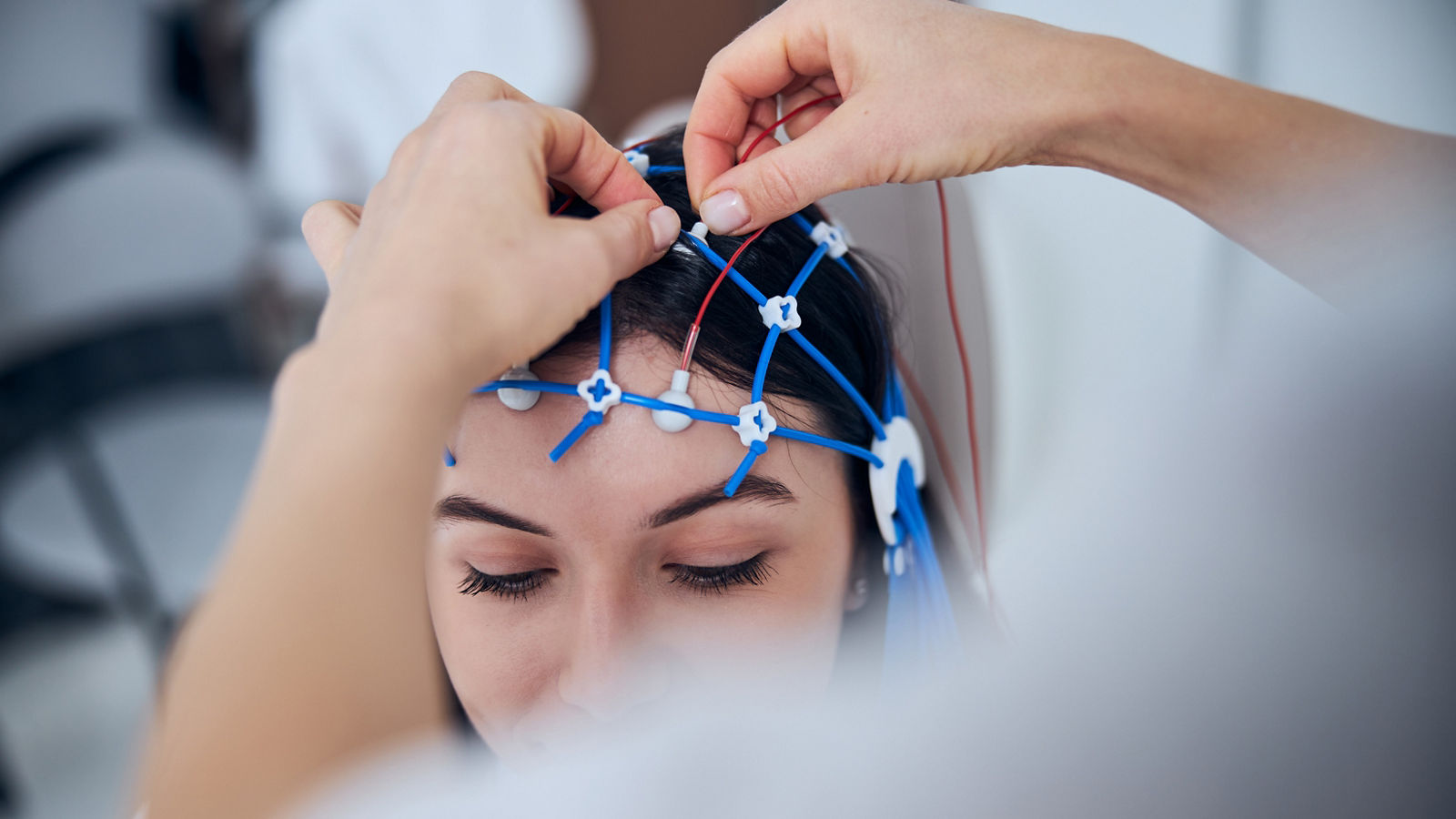 Qualified neurophysiologist placing the electrodes on the female scalp,Qualified neurophysiologist placing the electrodes on the female