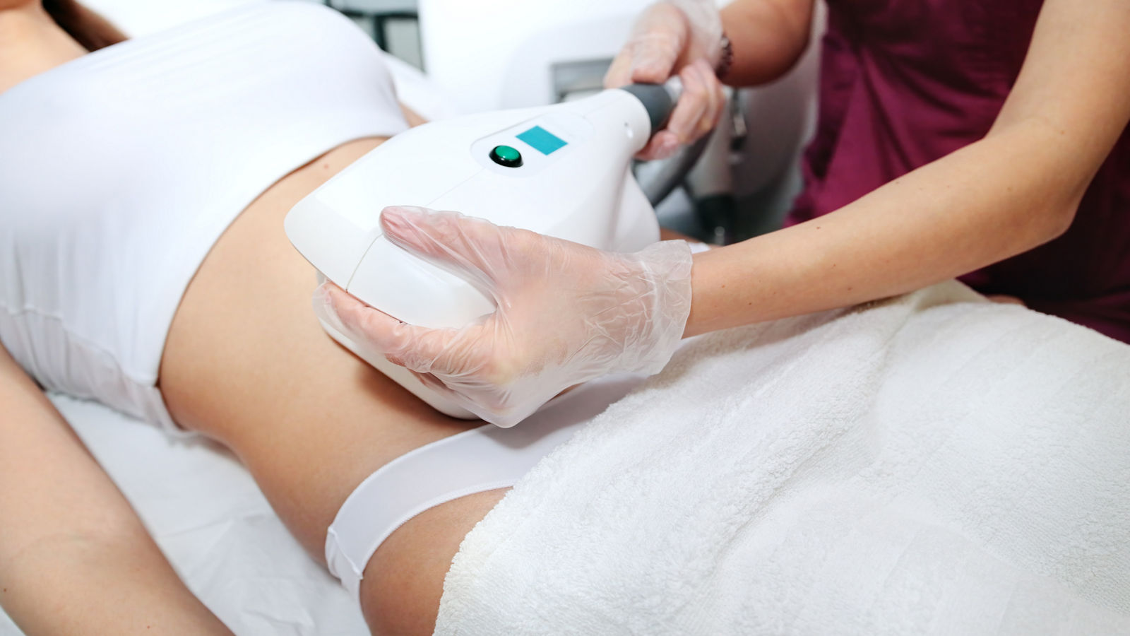 Young attractive woman in white bikini getting Cool sculpting procedure for body slimming. Cryolipolyse and body contouring treatment, anti-cellulite and anti-fat therapy in beauty salon