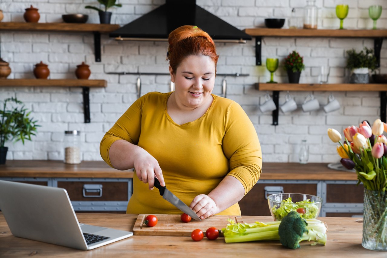 Plus size , fat caucasian woman learning to make salad and healthy food from social media,Social distancing, stay at home concept