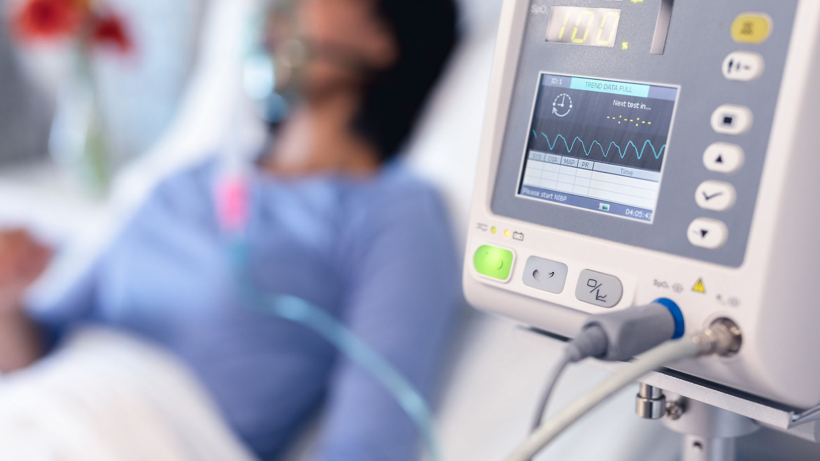 Ventilator monitor and african american female patient in hospital bed with oxygen ventilator
