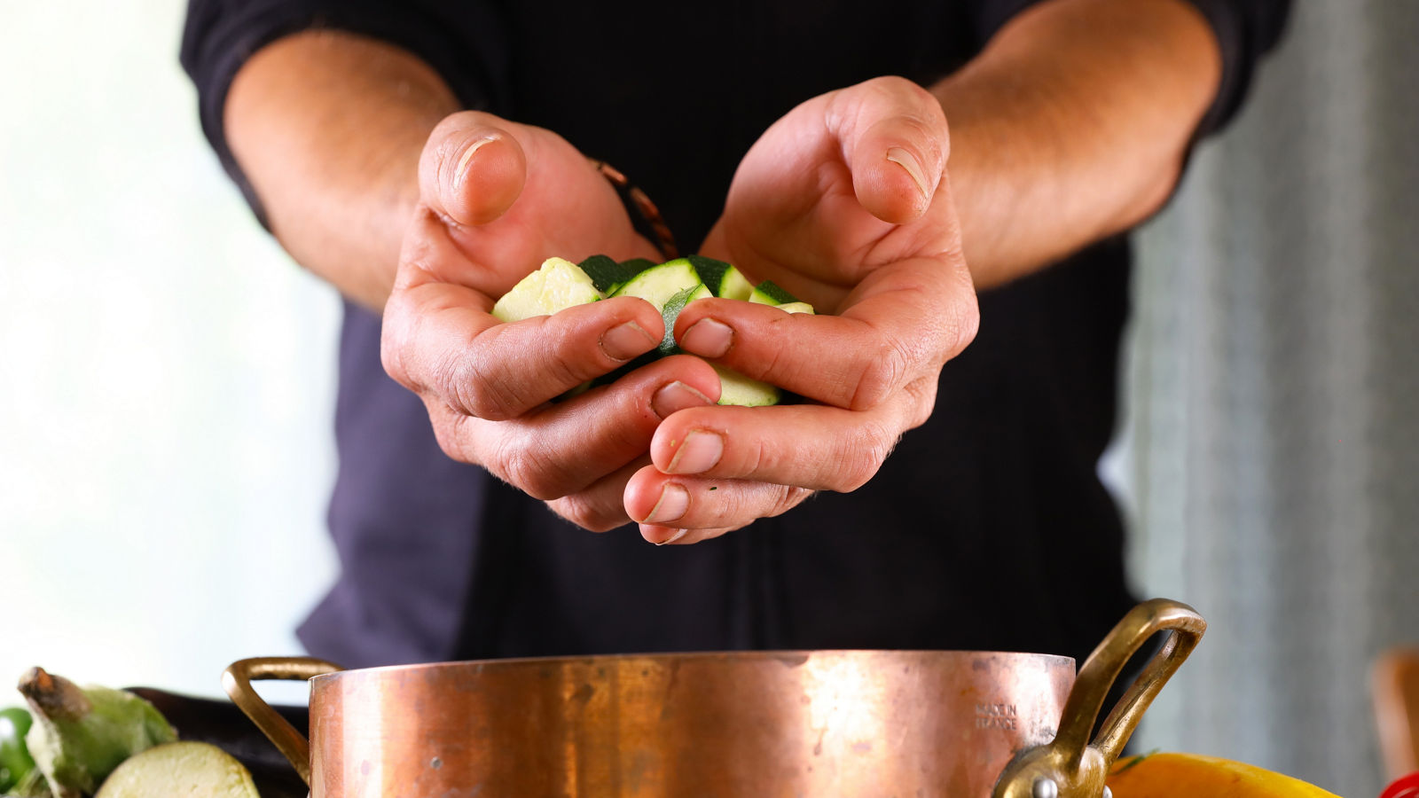 vegetables on man's hand for cooking ratatouille or vegetable dish