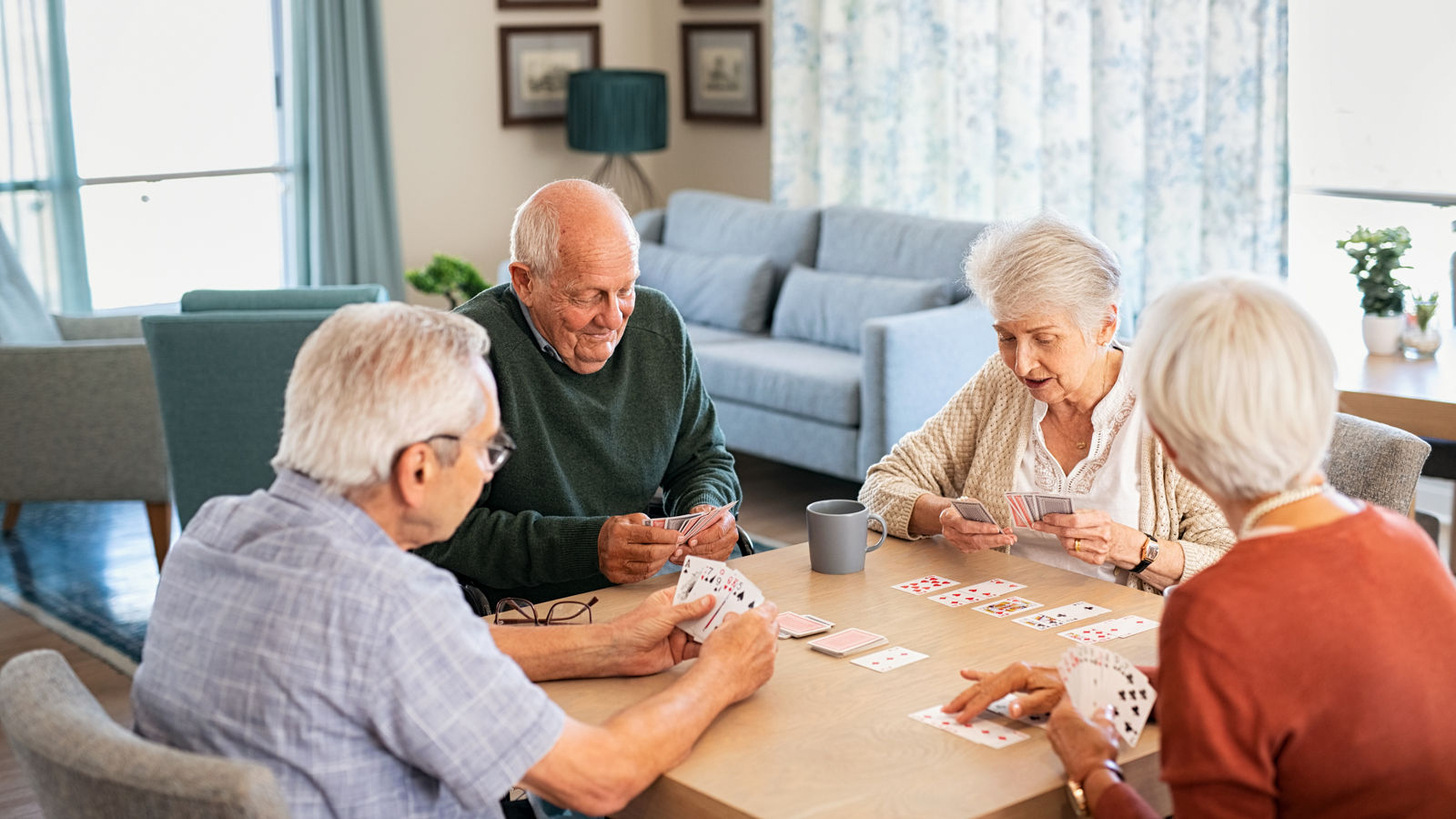 Senior friends playing cards together at nursing home