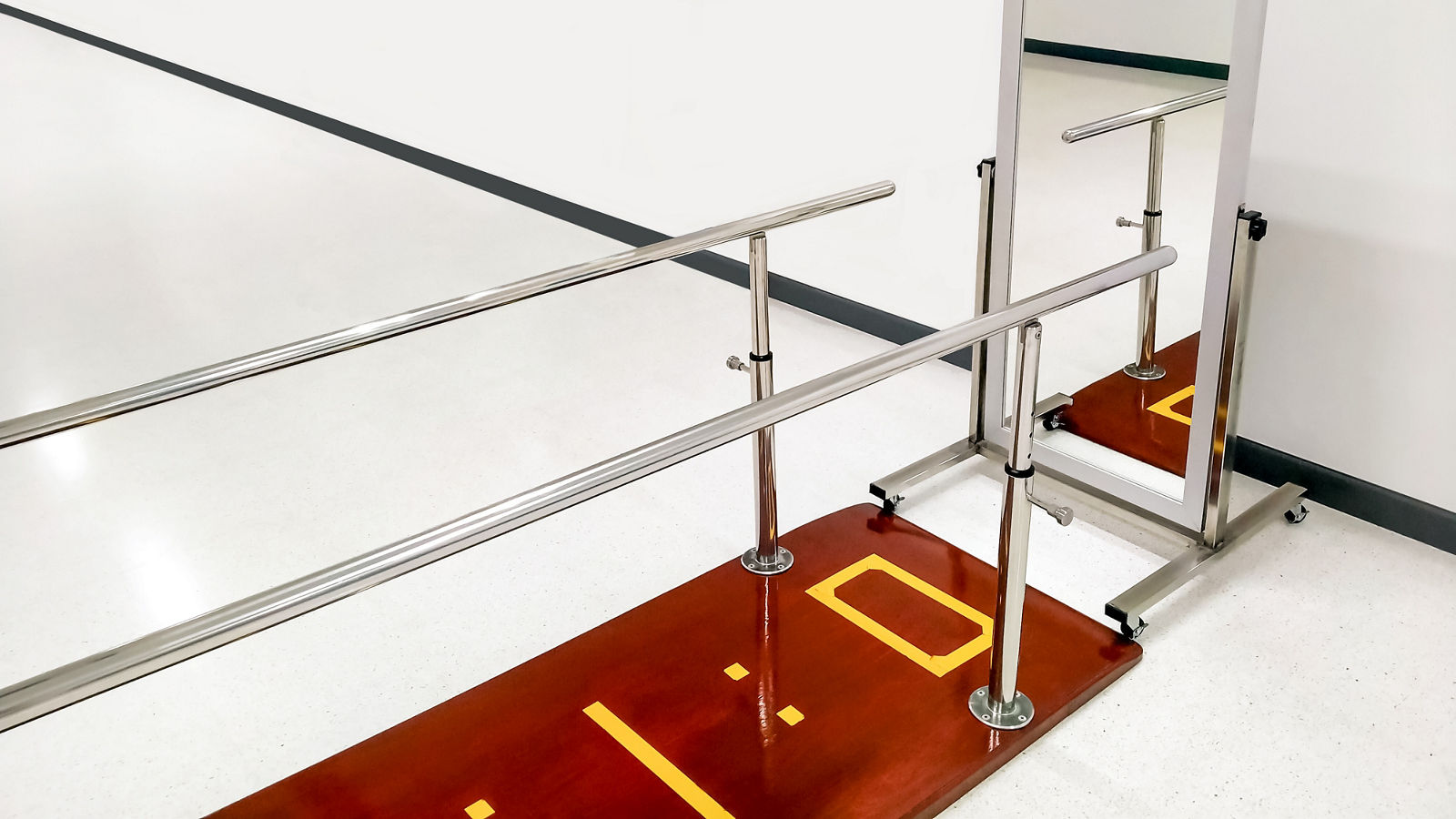 Rehab parallel bars with mirror in white room at rehabilitation center